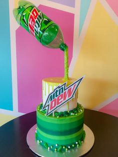 a birthday cake with a pepsi cola bottle pouring out the top and candy bar on top