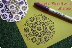 a crochet doily next to a pen on top of a piece of paper