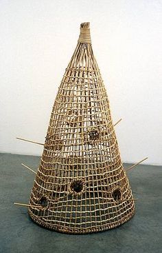 a wooden sculpture with sticks sticking out of it's sides and holes in the middle