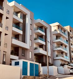 an apartment building with multiple balconies and blue doors