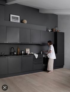 a woman standing in front of a kitchen counter