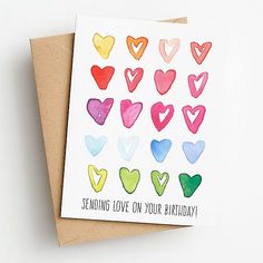 a card with watercolor hearts on it and the words sending love on your birthday