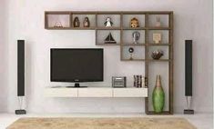 a living room with white walls and shelves on the wall, television is mounted to it's side