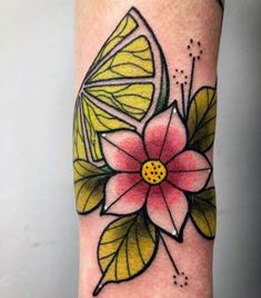 a colorful flower with leaves on the side of her leg is featured in this tattoo design