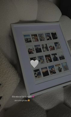 a white heart is placed on top of a photo frame with photos in the middle