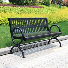 a black park bench sitting on top of a sidewalk