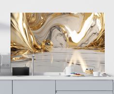 a kitchen with gold and white decor on the counter top, along with coffee mugs