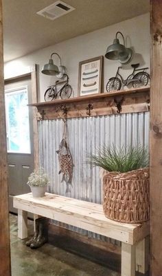 a wooden bench sitting in front of a wall with hanging plants and bicycles on it