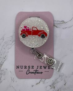 a badge with a red car on it sitting on top of a pink card holder