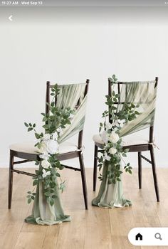 two chairs decorated with flowers and greenery