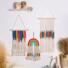 there are two wall hangings made out of macrame yarn and one has a rainbow on it