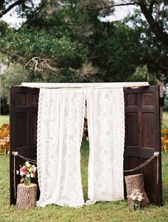 an outdoor ceremony setup with white curtains and flowers