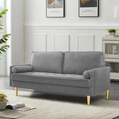 a living room scene with focus on the grey couch and white rugs that have been placed in front of it