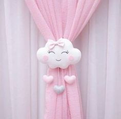 a pink curtain with a white cloud hanging from it's side and a light blue heart in the middle