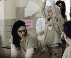 a group of women in scrubs standing around each other with their arms raised up