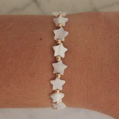 Handmade bracelet. Nacre star beads. Length: 6" plus 1" extender chain. Made in USA. White Star-shaped Jewelry With Adjustable Chain, Adjustable Star-shaped Jewelry With Spacer Beads, Adjustable Star Shaped Jewelry With Spacer Beads, White Star-shaped Adjustable Beaded Bracelets, Adjustable White Star-shaped Beaded Bracelets, White Charm Bracelet With Star Charm As Gift, Adjustable White Bracelet With Star Charm, Adjustable White Star Charm Bracelet, Adjustable White Charm Bracelet With Star Charm