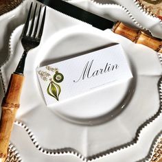 a white plate topped with a fork and knife next to a napkin that says martin