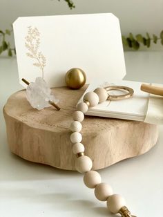 a wooden beaded necklace on a table next to a notepad and ring holder