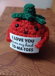 a red stuffed tomato with a sign that says i love you from my head to matees