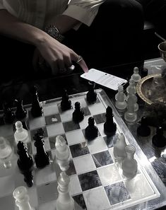 a man is playing chess on a glass table