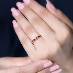 a woman's hand with pink manicured nails and a ring on her finger