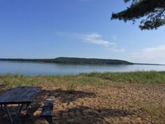 a picnic table on the shore of a lake