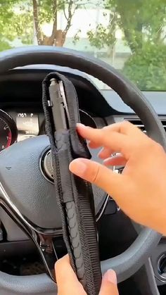 a person is holding the steering wheel cover in their hand and pressing it down on the dashboard