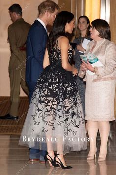 two women and one man are talking to each other in front of some people at an event