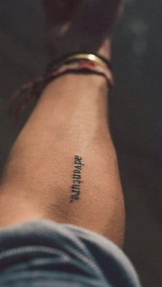 a person with a small tattoo on their left arm that reads,'strength '