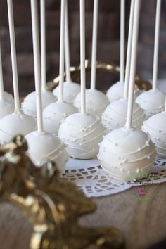 there are many white cake pops on the table