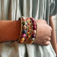 Two rows of colorful Kantha beads bookend a row of braided Sari textiles. Each is accented with matte gold seed beads for a subtle pop of shimmer. Made from repurposed Kantha textiles so the colors and patterns will vary slightly. Sustainably handmade by women artisans in India. Multicolor Bohemian Beaded Bracelet For Festive Occasions, Multicolor Bohemian Beaded Bracelets For Festive Occasions, Festive Bohemian Beaded Bracelets With Colorful Beads, Adjustable Multicolor Beaded Bracelet For Festive Occasions, Multicolor Bohemian Beaded Bracelets Fair Trade, Multicolor Handmade Beaded Bracelets For Festive Occasions, Bohemian Multicolor Fair Trade Beaded Bracelets, Festive Bohemian Colorful Beaded Bracelets, Multicolor Artisan Beaded Bracelets Fair Trade