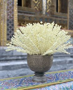 a vase with white flowers in it sitting on a table