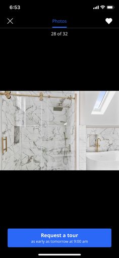 a bathroom with white marble walls and flooring, including a shower stall in the middle