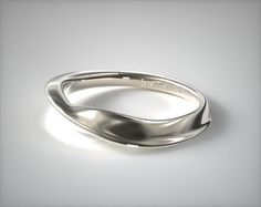 a silver ring on a white surface