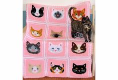 a crocheted blanket with cats on it and a cat standing next to it