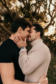 two men embracing each other in front of trees