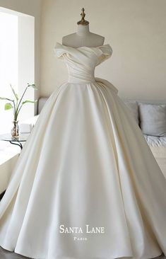 a white wedding dress on display in a room