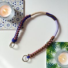 a candle is sitting on top of a table next to a piece of paper and some string