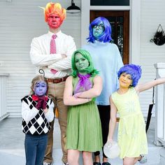 a group of people in costumes standing on the front porch with their arms folded out