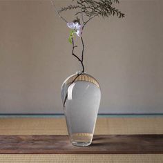 there is a vase with flowers in it on the floor next to a wall and rug