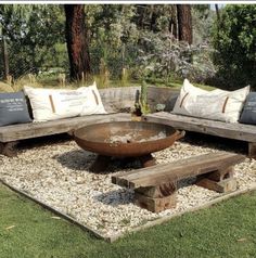 an outdoor seating area with wooden benches and pillows