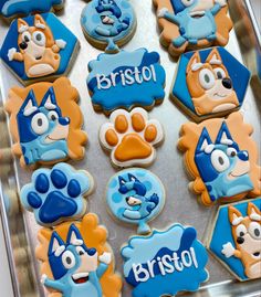 decorated cookies with blue and orange frosting are on a cookie sheet that says bristol