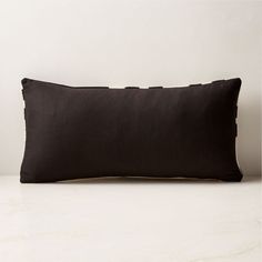 a black pillow sitting on top of a white table