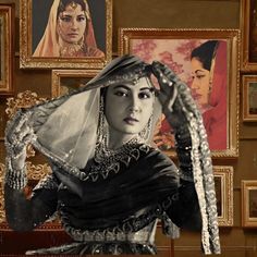 a woman wearing a veil and holding her hair in front of pictures on the wall