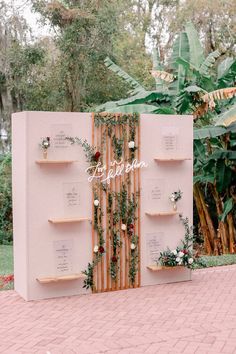 an outdoor ceremony area with pink walls and greenery