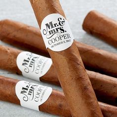 four cigars are lined up on the floor and one has a sticker that says mr & mrs cooper