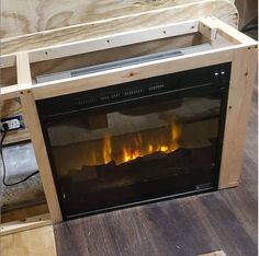 an electric fireplace in a wooden frame with fire flames on the front and back sides