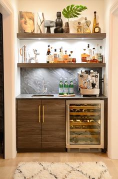 an appliance with bottles and glasses on the shelves above it is displaying wine