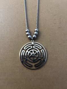 a silver necklace with a circular design on it