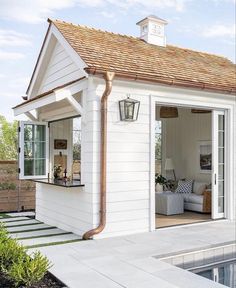 a small white house sitting next to a swimming pool